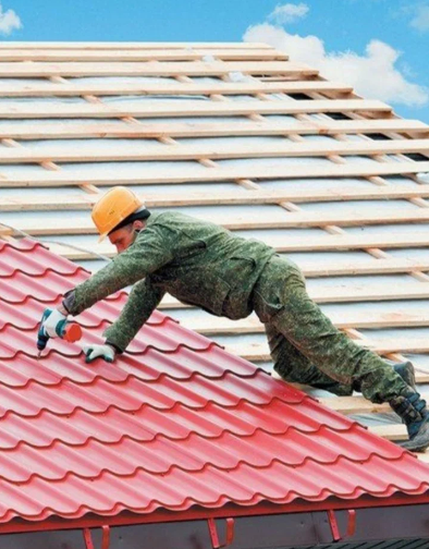 a man on a roof with a helmet and gloves