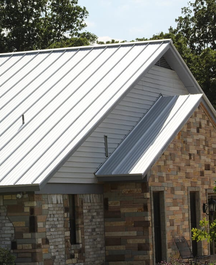 a brick house with a metal roof and a clock