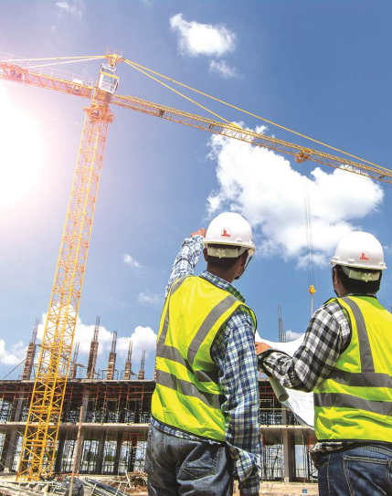 two construction workers standing in front of a building under construction